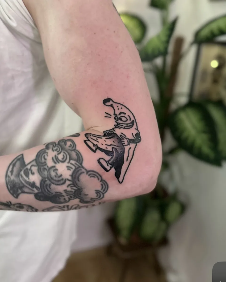 Tatuaż bananowej postaci w stylu ignorant na przedramieniu (2) — Tattoo, Wujek Darek Tattoo, Warszawa