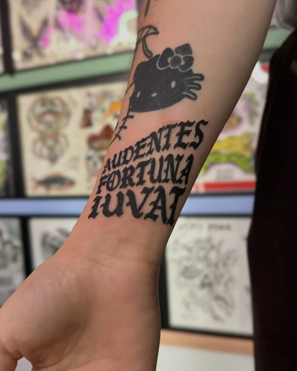 Ignorant tatuaż Hello Kitty i trzyliniowy napis na przedramieniu — Tattoo, Wujek Darek Tattoo, Warszawa