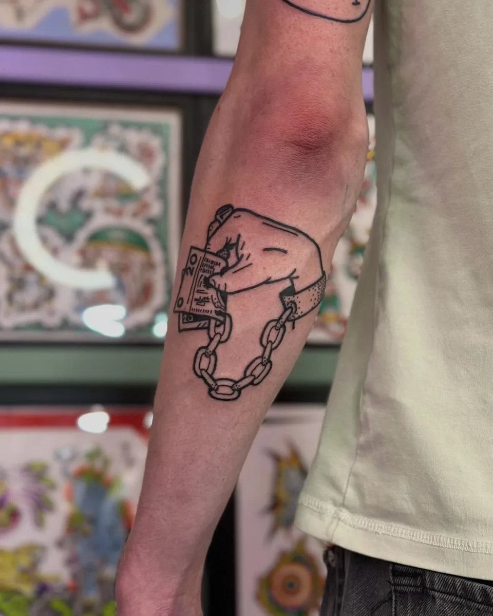 Ignorant tatuaż zaciśniętej pięści z banknotami i łańcuchem na przedramieniu (2) — Tattoo, Wujek Darek Tattoo, Warszawa