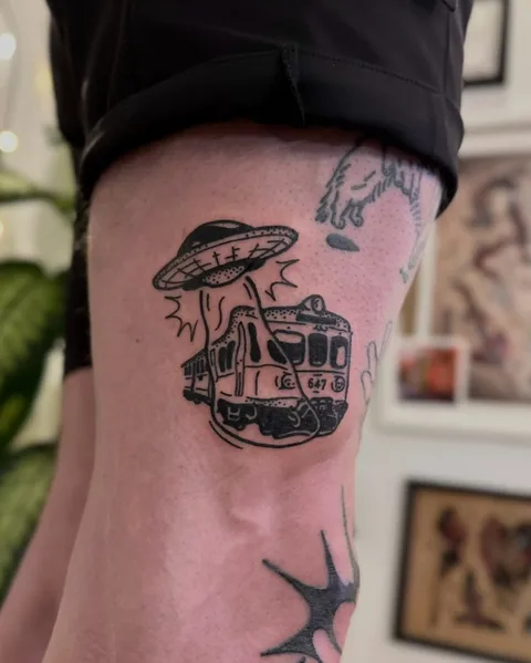 Ignorant tatuaż UFO porywającego tramwaj na nodze (2) — Tattoo, Wujek Darek Tattoo, Warszawa