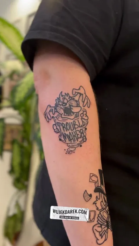 Ignorant tatuaż Taz Diabeł Tasmański z napisem na ramieniu — Tattoo, Wujek Darek Tattoo, Warszawa