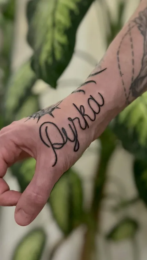 Tatuaż z napisem w stylu kaligraficznym na grzbiecie dłoni — Tattoo, Wujek Darek Tattoo, Warszawa