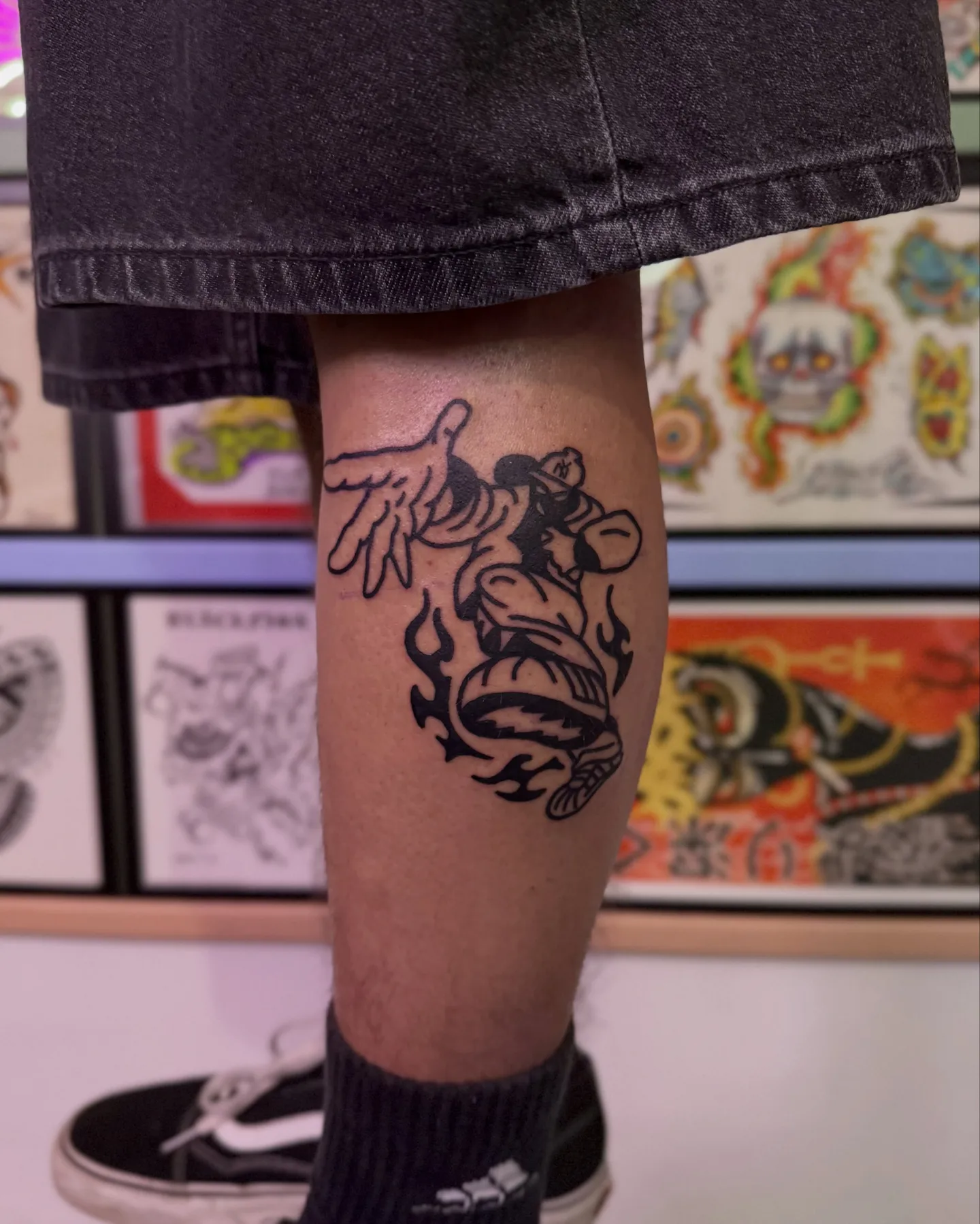 Gruby kontur tatuaż postaci w czapce z płomieniami na łydce (2) — Tattoo, Wujek Darek Tattoo, Warszawa