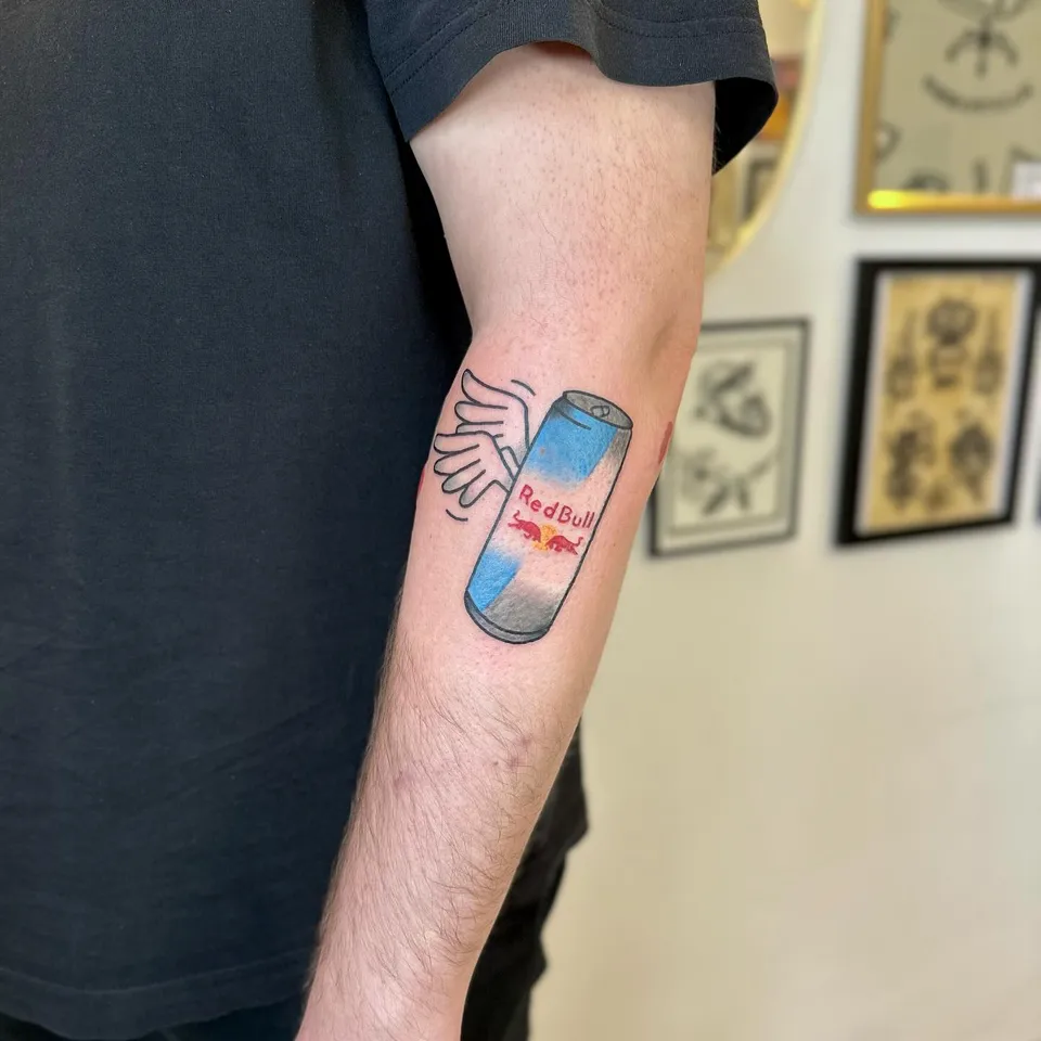 Ignorant tatuaż puszki energetyka ze skrzydłami na przedramieniu — Tattoo, Wujek Darek Tattoo, Warszawa