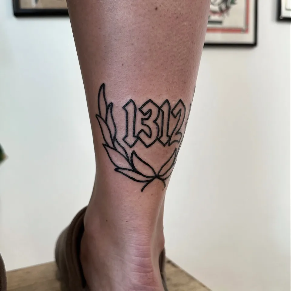 Ignorant tatuaż z numerycznym letteringiem i wieńcem liści na kostce — Tattoo, Wujek Darek Tattoo, Warszawa