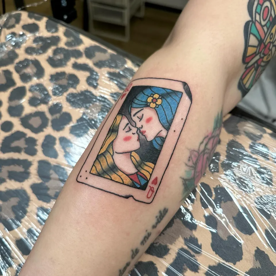 Tatuaż karty do gry z całującymi się kobietami na przedramieniu — Tattoo, Wujek Darek Tattoo, Warszawa