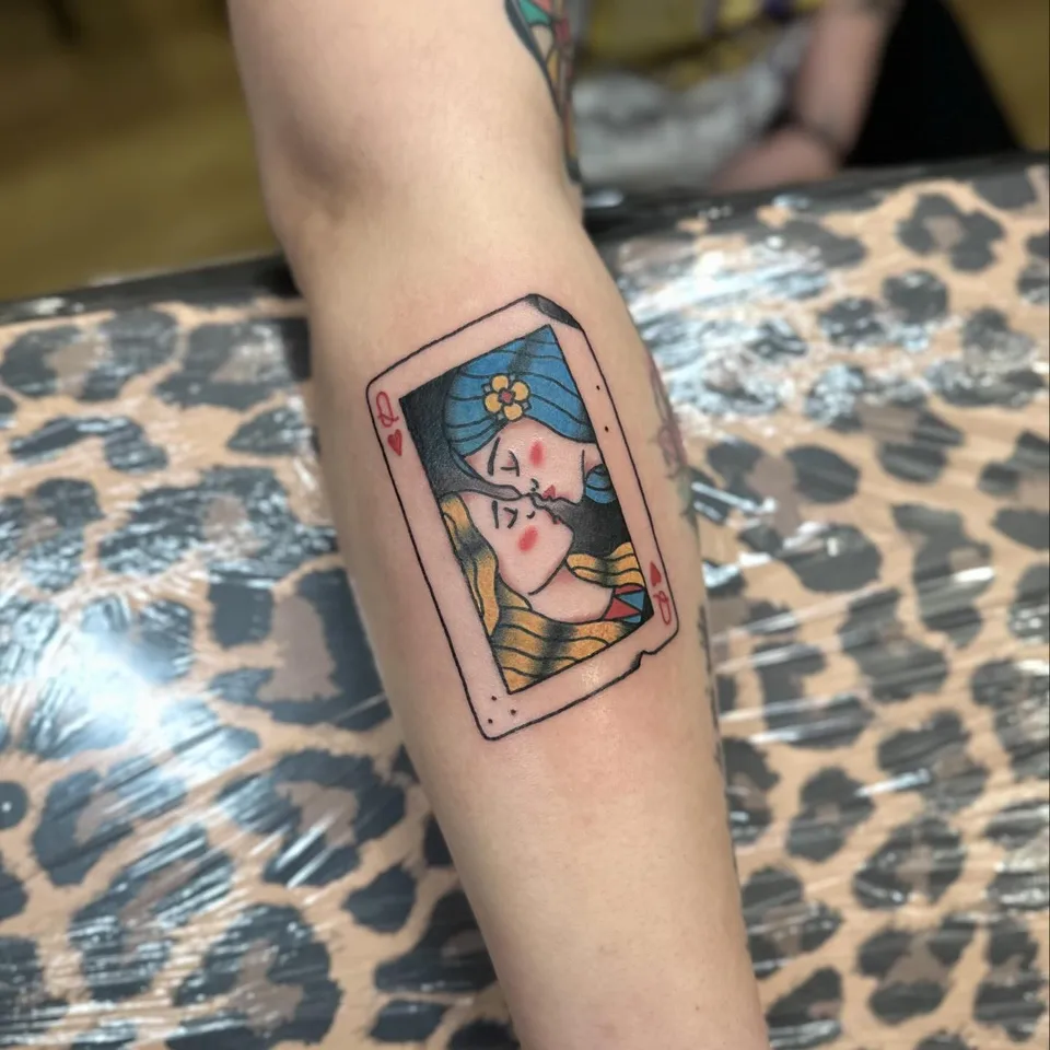 Tatuaż karty do gry z całującymi się kobietami na przedramieniu (2) — Tattoo, Wujek Darek Tattoo, Warszawa