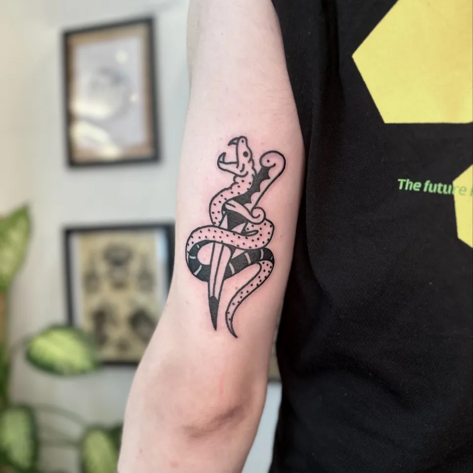 Ignorant tatuaż węża owiniętego wokół sztyletu na przedramieniu — Tattoo, Wujek Darek Tattoo, Warszawa