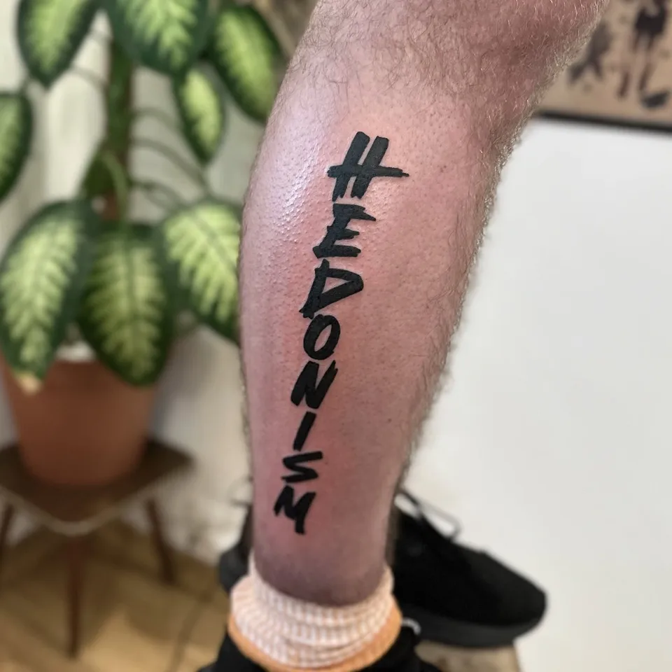 Ignorant tatuaż z pionowym napisem na łydce – gruby kontur — Tattoo, Wujek Darek Tattoo, Warszawa