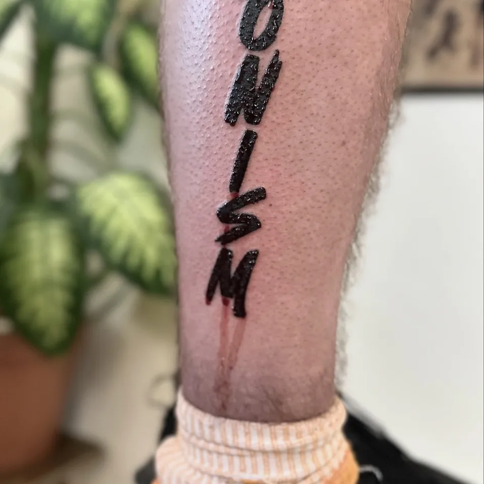 Ignorant tatuaż z pionowym napisem na łydce – gruby kontur (3) — Tattoo, Wujek Darek Tattoo, Warszawa