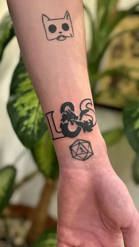 Ignorant tatuaż z kotem, smokiem i dwudziestościenną kością na przedramieniu — Tattoo, Wujek Darek Tattoo, Warszawa